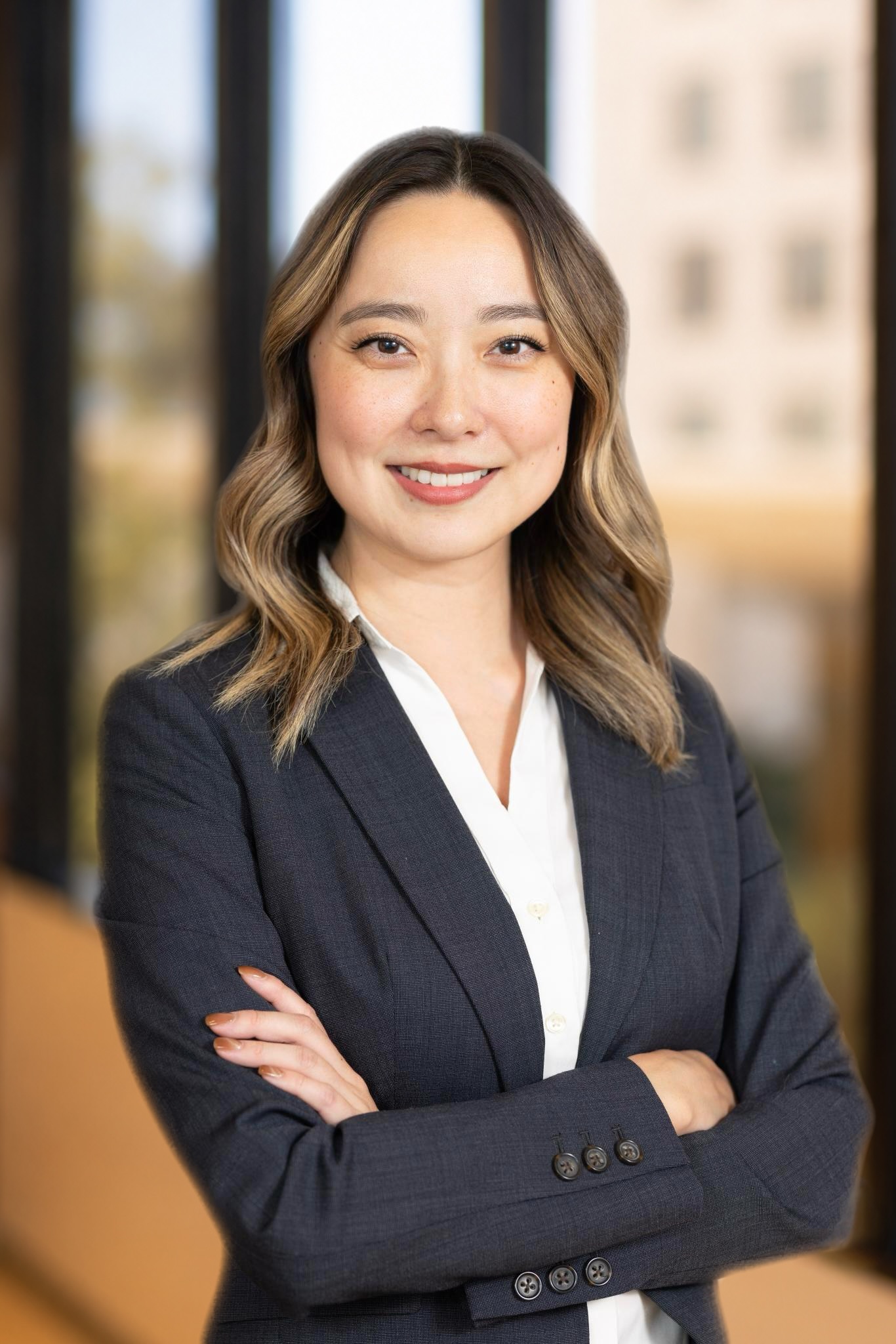 Casie Yan, VP, Product at Post Acute Analytics, in a charcoal blazer and white blouse in a modern office