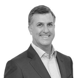Black and white portrait of James T. Olsen, Board Member at Post Acute Analytics, in a dark blazer and striped shirt
