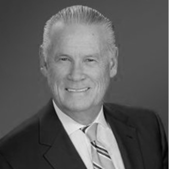 Black and white portrait of John F. Taylor, Chairman of the Board of Directors at Post Acute Analytics, in a dark suit and striped tie