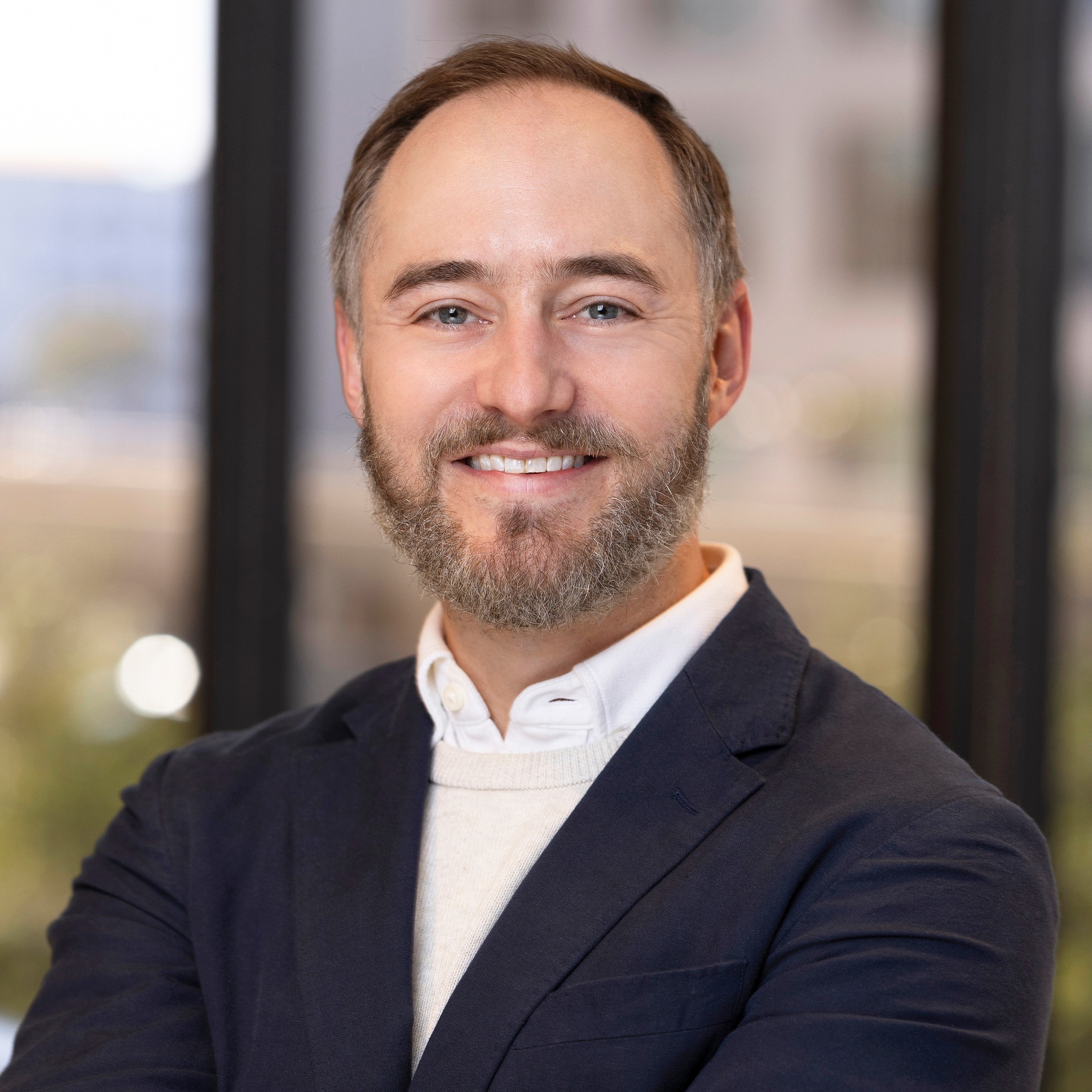 Mark Strait, VP, Client Success at Post Acute Analytics, in a navy blazer over a cream sweater in a modern office